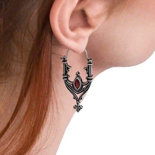 Pendientes inspirados en las catedrales góticas con cruces y piedra roja central estilo whimsigoth fabricado en latón y plata de Restlye vista en modelo