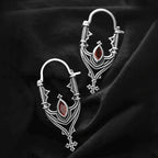 Pendientes inspirados en las catedrales góticas con cruces y piedra roja central estilo whimsigoth fabricado en latón y plata de Restlye vista sobre fondo negro