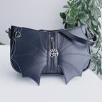 Video de detalle de bolso Malachi Batwing con solapas en forma de murciélago en el frente y silueta baguette de Banned Alternative