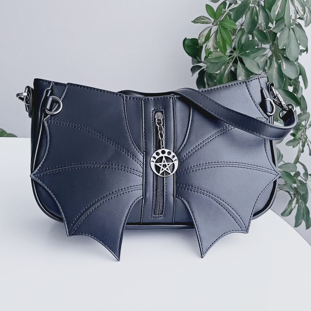 Video de detalle de bolso Malachi Batwing con solapas en forma de murciélago en el frente y silueta baguette de Banned Alternative