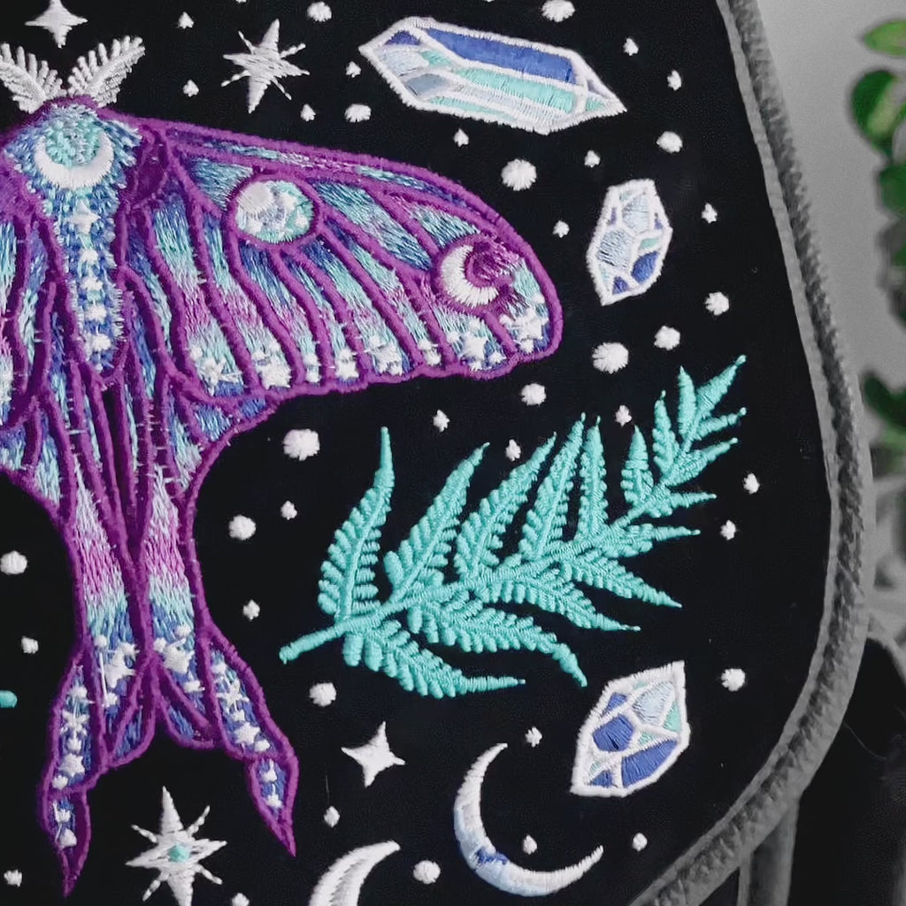 Detalle de bordado de mochila gótica estilo whimsigoth con cristales, polilla y helechos bordados en tonos fríos modelo Enchanted Forest de Restyle
