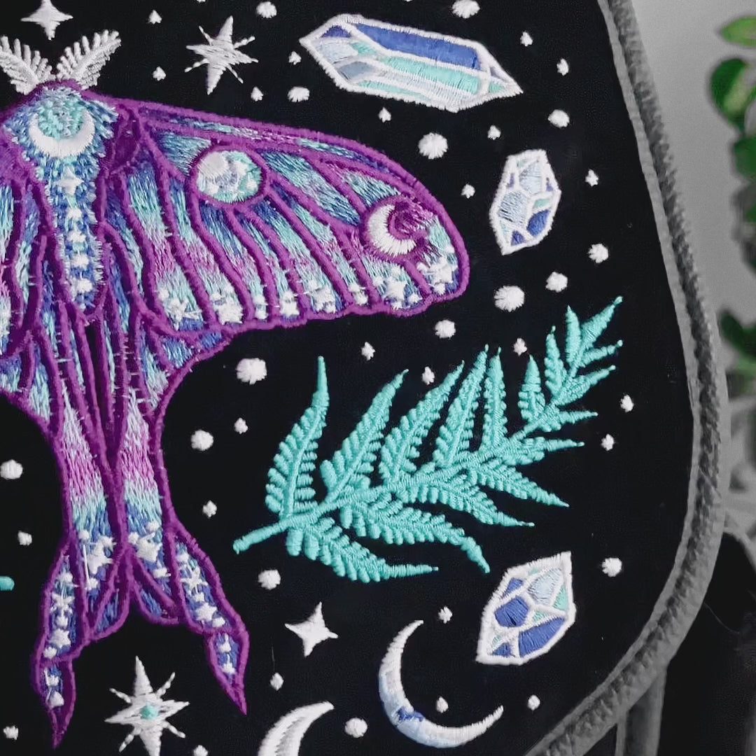 Detalle de bordado de mochila gótica estilo whimsigoth con cristales, polilla y helechos bordados en tonos fríos modelo Enchanted Forest de Restyle