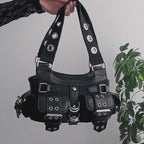 Video de detalles de bolso baguette con remaches y hebillas metálicas estilo y2k con múltiples bolsillos utilitarios.