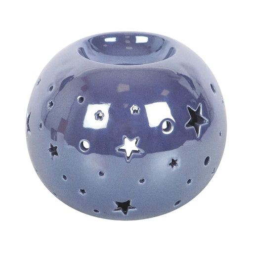 Quemador de aceite en forma de bola con estrellas perforadas en color morado iridiscente vista frontal sobre fondo blanco.