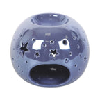 Quemador de aceite en forma de bola con estrellas perforadas en color morado iridiscente vista parte posterior espacio para vela sobre fondo blanco.