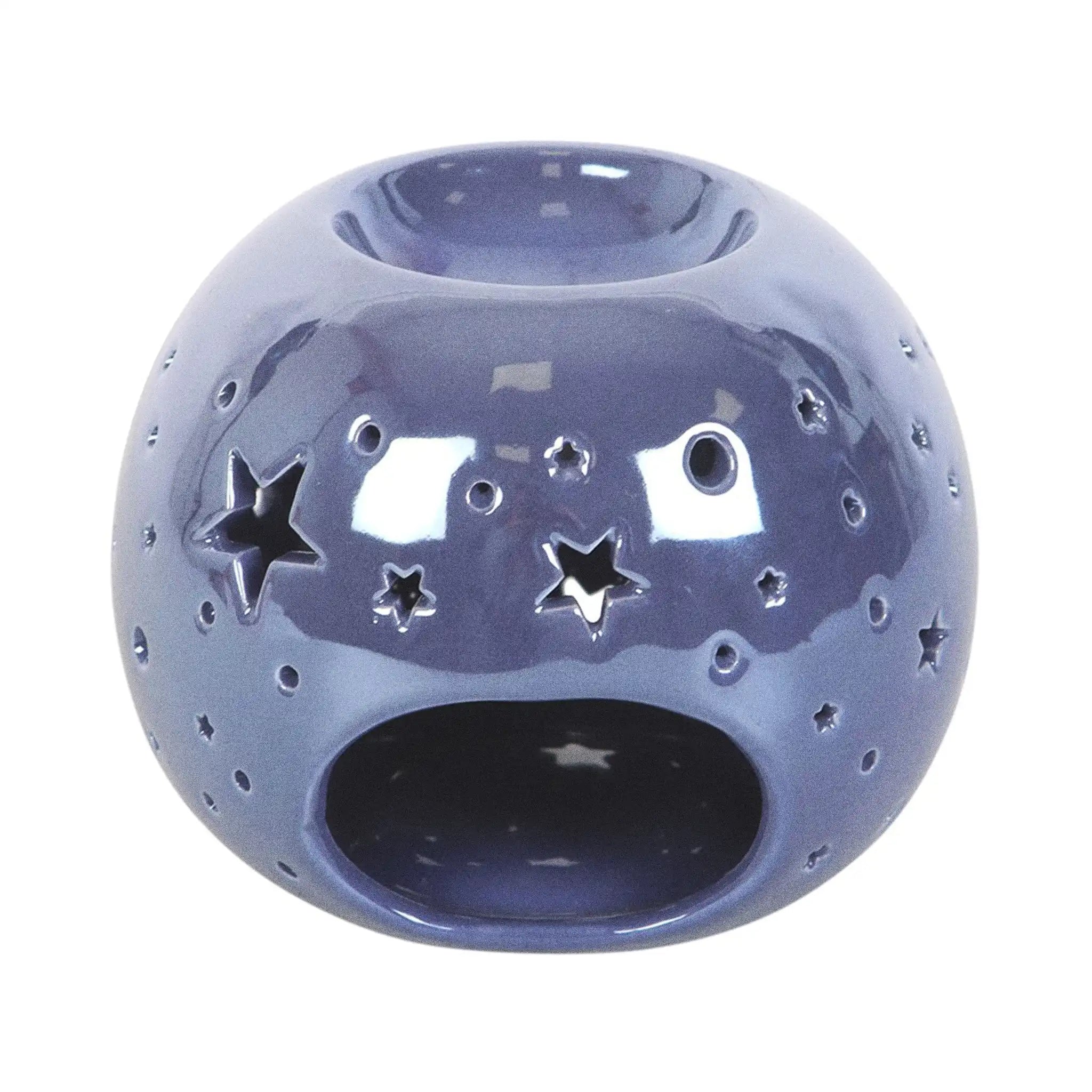 Quemador de aceite en forma de bola con estrellas perforadas en color morado iridiscente vista parte posterior espacio para vela sobre fondo blanco.