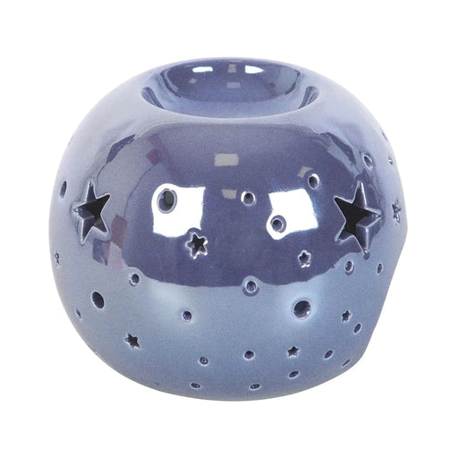 Quemador de aceite en forma de bola con estrellas perforadas en color morado iridiscente vista lateral sobre fondo blanco.