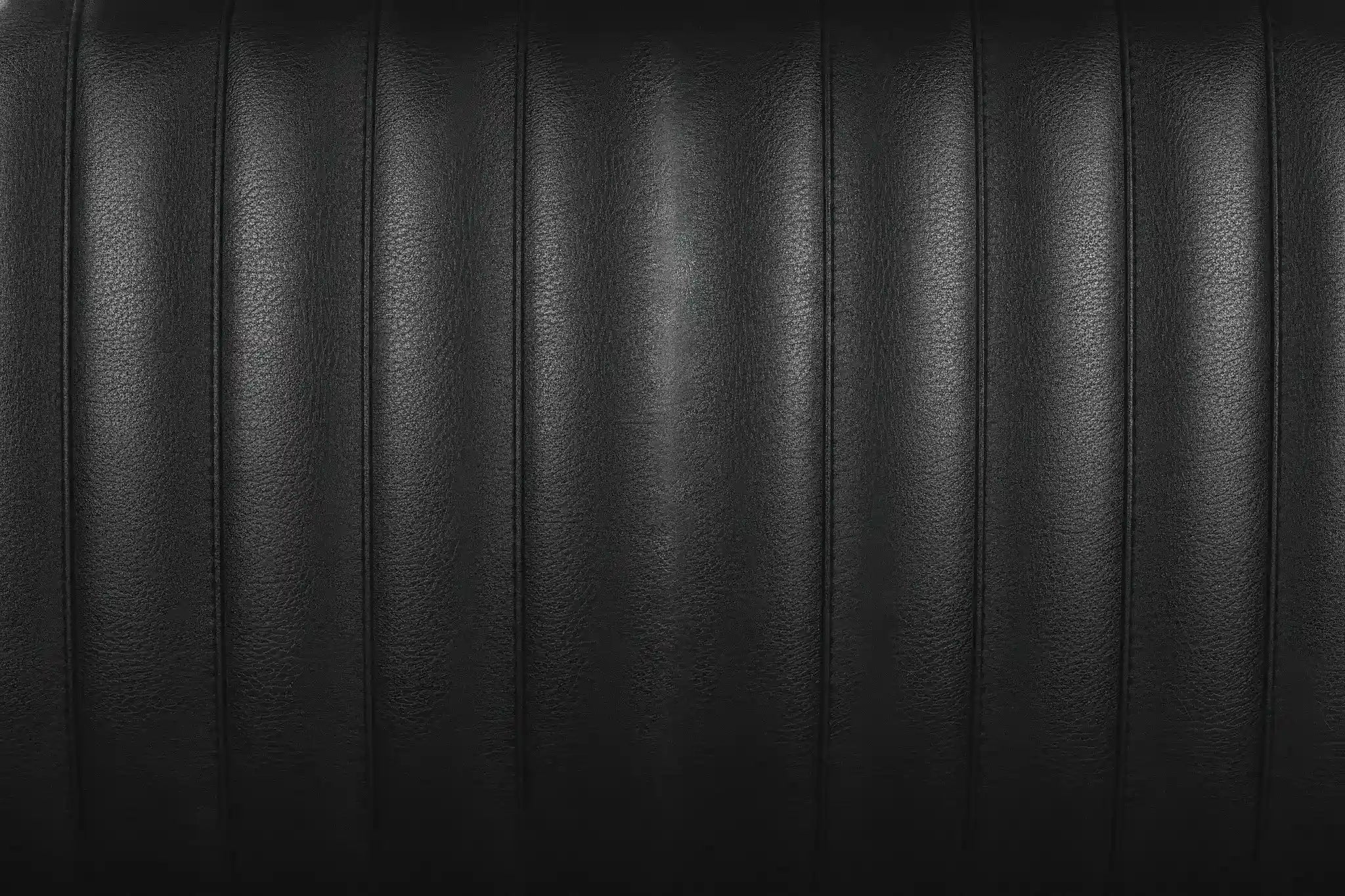 Matte black leather texture with 1950s tuck and roll stitching