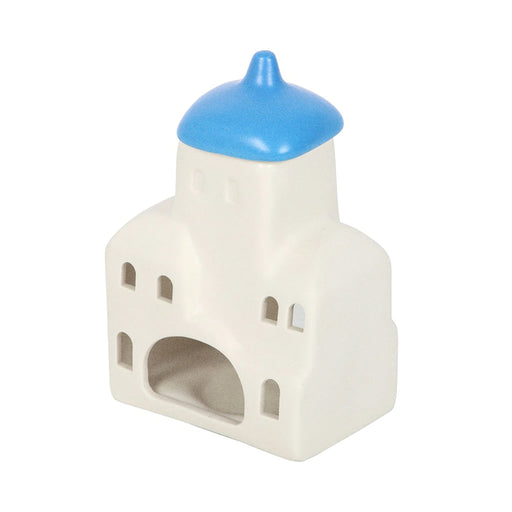 Quemador de aceites esenciales y calentador de cera con forma de casa de Santorini inspirado en Grecia en blanco y azul vista posterior de abertura para vela sobre fondo blanco.