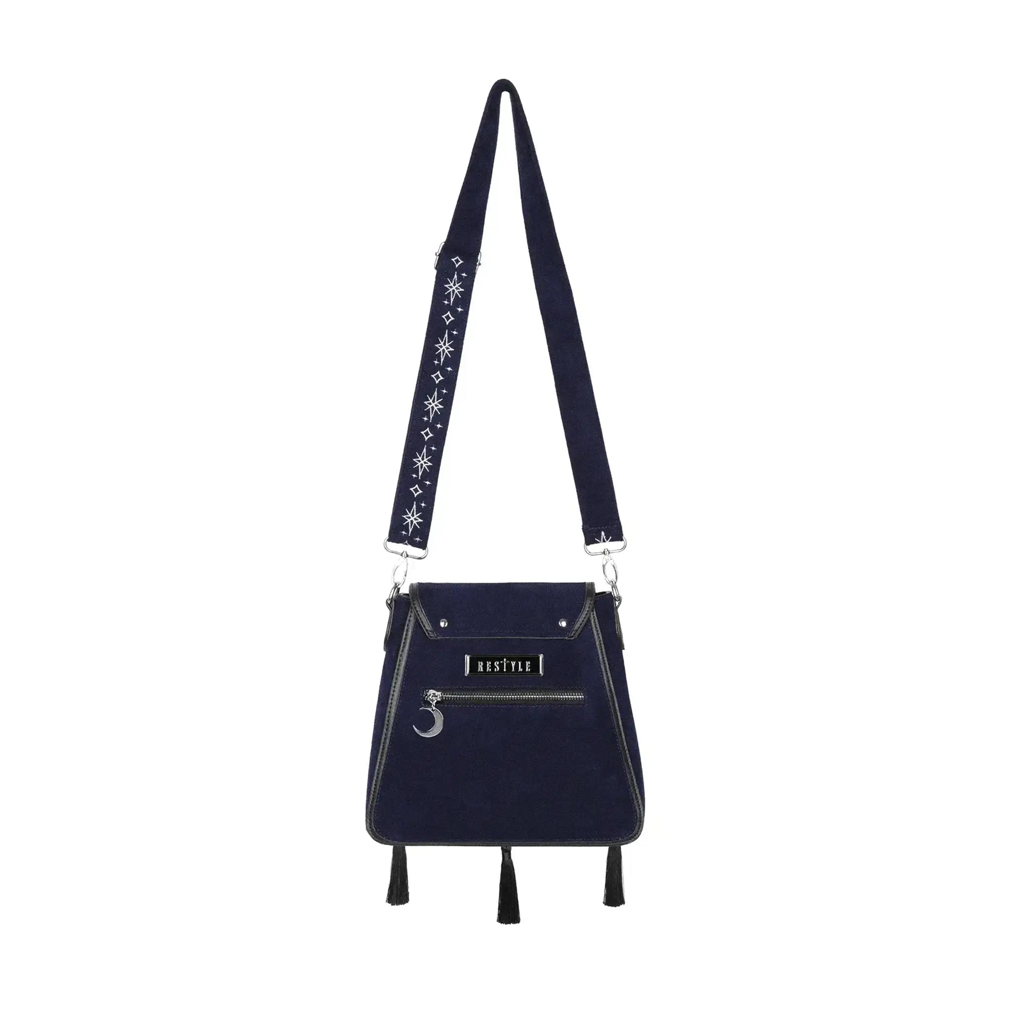 Bolso rígido en azul medianoche con ribetes en negro, bordado en tonos plateados con un diseño celestial de polilla, luna, estrellas y vegetación estilo whimsigoth. Borlas decorativas en la solapa. Vista posterior completa con correa 