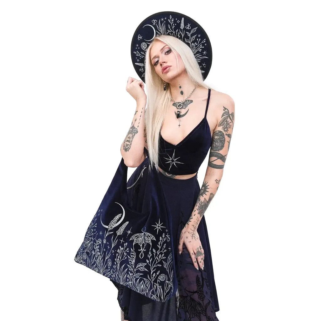 Bolso hobo en color azul medianoche con bordado en hilo plateado de luna, polilla y jardín del bosque tipo tote vista con modelo en brazo
