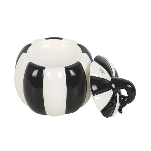Quemador de aceites esenciales con forma de calabaza a rayas blancas y negras estilo gótico, witchy o alternativo vista frontal sin tapa sobre fondo blanco.