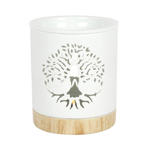 Quemador de aceites esenciales y calentador de cera con diseño de árbol de la vida calado sobre cerámica y base de madera vista frontal sobre fondo blanco.