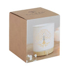 Quemador de aceites esenciales y calentador de cera con diseño de árbol de la vida calado sobre cerámica y base de madera vista packaging sobre fondo blanco.