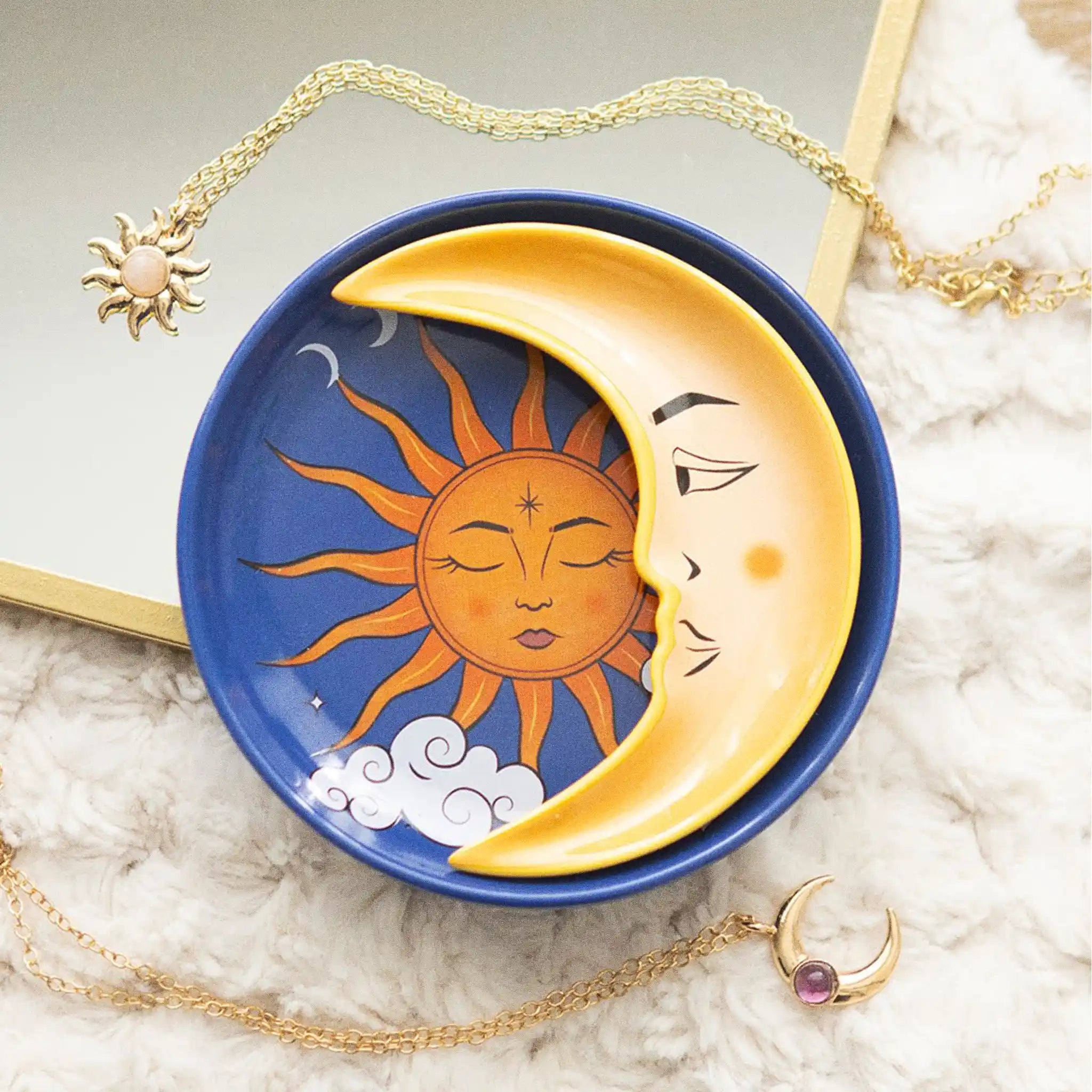 Plato apilable con forma de sol y luna en estilo whimsical vista de ambos platos sobre manta con collares al rededor.