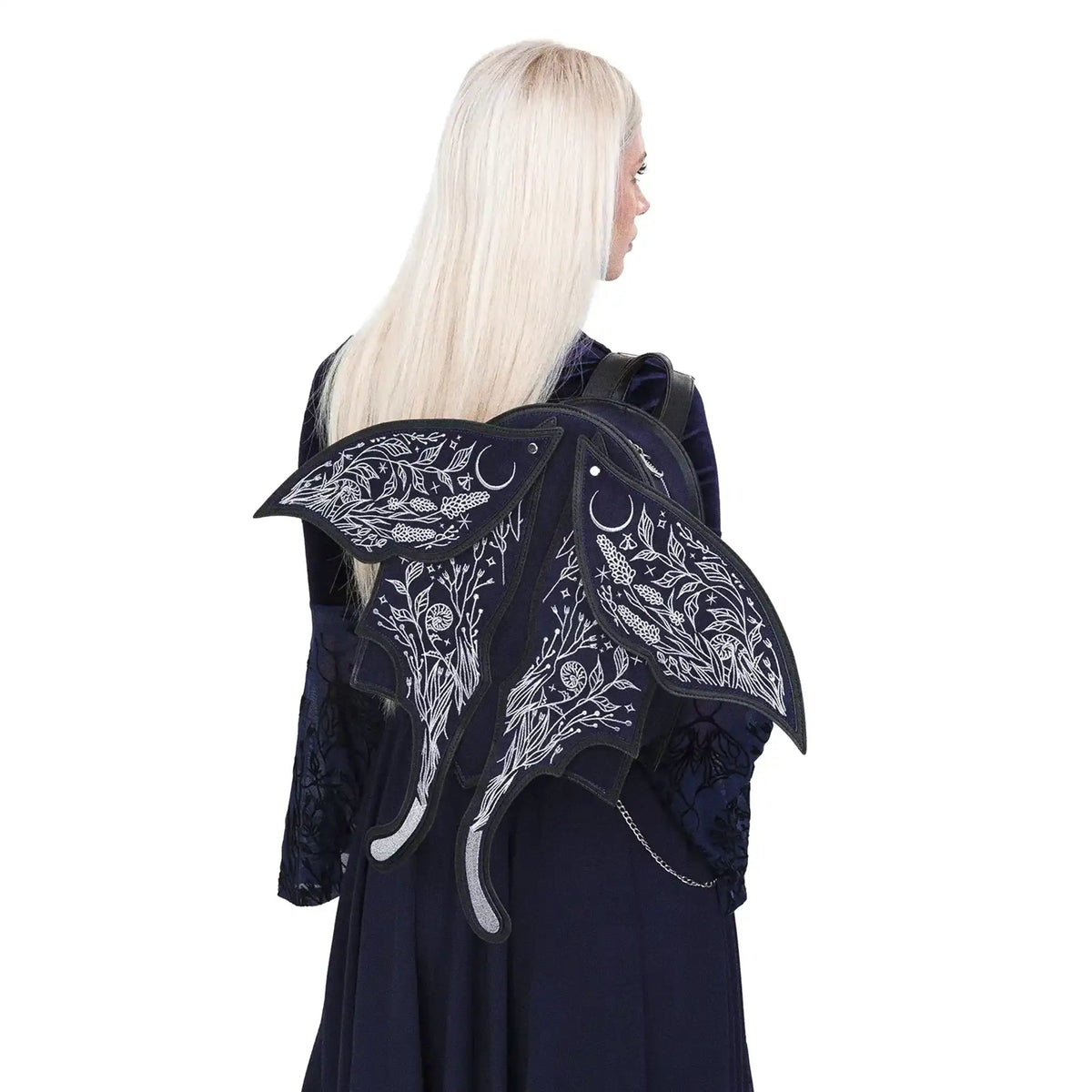 Mochila con alas móviles bordadas en plateado sobre un fondo azul medianoche con detalles contrastados en negro estética whimsigoth y fairycore modelo Umbra Noctis de Restyle vista con modelo en hombro