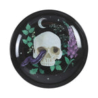 Plato para joyería con diseño de calavera, serpiente y plantas estilo gótico visto desde arriba con fondo blanco.