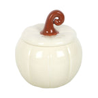 Quemador de aceites esenciales de cerámica con forma de calabaza con tallo rizado en blanco roto y marrón estilo aesthetic para otoño y halloween vista frontal sobre fondo blanco.