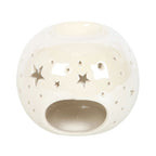 Quemador de aceites esenciales y calentador de ceras aromáticas con forma de bola con estrellas caladas en color blanco iridiscente vista parte posterior de abertura para vela sobre fondo blanco.