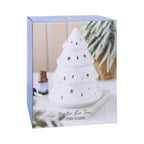 Quemador de aceites esenciales con forma de árbol de navidad y estrellas y gotas cut out en la superficie vista packaging sobre fondo blanco.