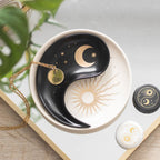 Plato para joyería yin yang con diseño apilable en dos piezas estilo whimsical visto desde arriba encima de un escritorio y con joyería al rededor.