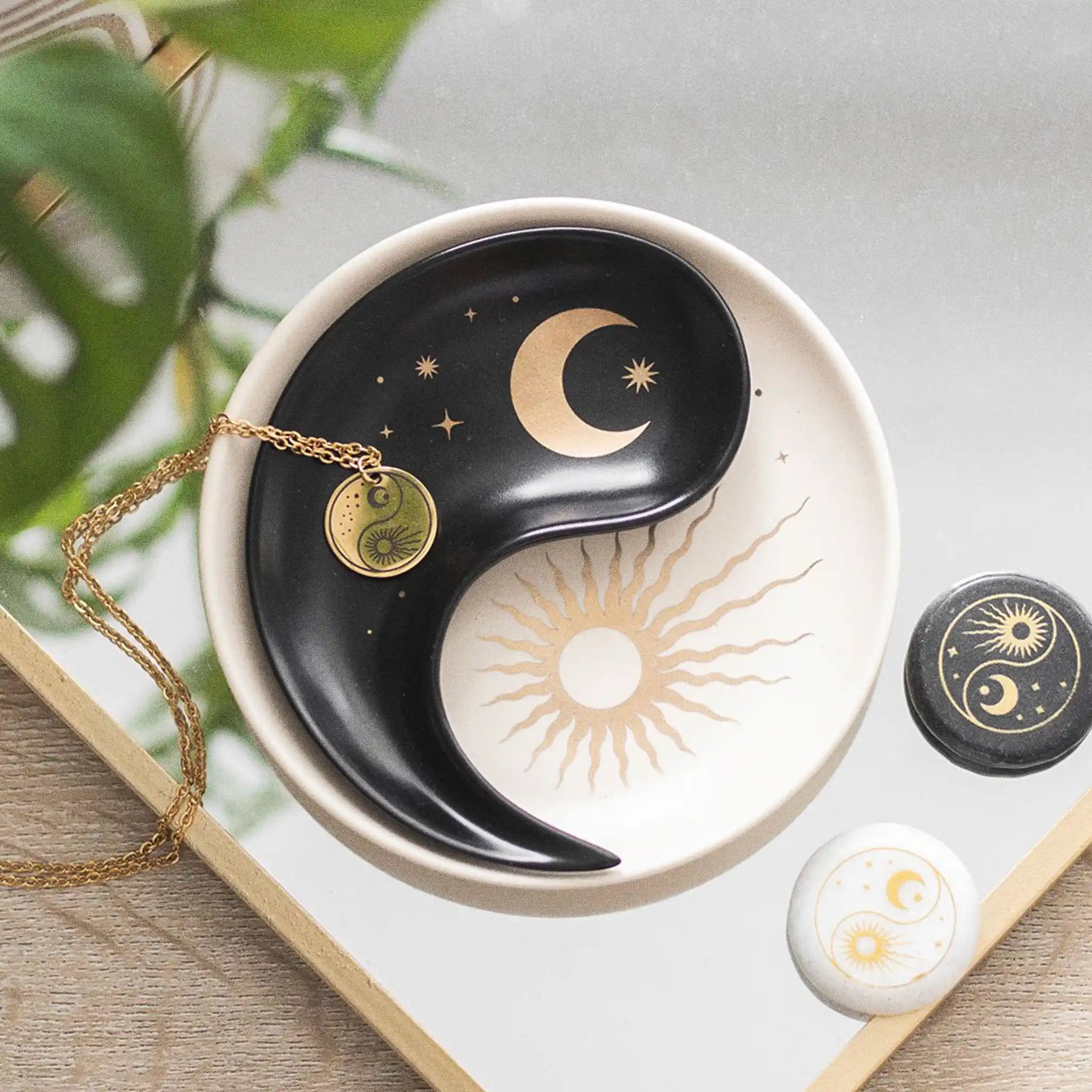 Plato para joyería yin yang con diseño apilable en dos piezas estilo whimsical visto desde arriba encima de un escritorio y con joyería al rededor.